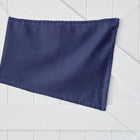 Ein KraftKids Sonnensegel Leinen blau dunkelblau, eine rechteckige Fahne aus 100% Leinen, ist schräg an eine weiße Holztafelwand gepinnt.