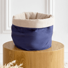 Das runde Stoffkörbchen "Körbchen rund Leinen blau dunkelblau" von KraftKids mit navy-blauem Leinen steht auf einem Holzpodest vor weißer Wand, dekoriert mit beigen Cord-Details und getrockneten Gräsern in der Ecke.