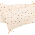 Zwei rechteckige KraftKids Bettumrandung Nestchen Musselin Kirschen Kissen in zartem Pfirsich mit orangefarbenen Kirschenaufdrucken und Bindebändern, aus atmungsaktiver Baumwolle - ideal als Bettumrandung für ein Kinderbettchen. Ein Kissen überlappt das andere.