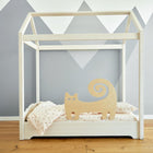 Der KraftKids Rausfallschutz aus Leimholz Katze ist ein minimalistisches Kinderbett mit einem hölzernen Katzenausschnitt, hell gemustertem Bettzeug und einer mit grauen Bergformen verzierten Wand.