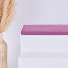 Eine hohe geflochtene Vase mit beigem Pampasgras steht neben weißen Stufen, die oberste Stufe wird von einer gefalteten KraftKids GmbH Sitzauflage für Ikea TROFAST Musselin purpur aus doppellagigem Musselin in zartem Lila gekrönt.