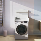 Der KraftKids Wickelaufsatz weiß, ein Wickelaufsatz für Waschmaschinen und Trockner mit rückseitiger Ablage, steht in einem platzsparenden Badezimmer neben gefalteten Handtüchern, einem Handtuchhalter und einem kleinen rosa Mülleimer.