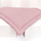 Die KraftKids Wickelauflage Waffel Piqué rosa, ein zartrosa Kissen mit strukturiertem Stoff, ist über weiße Würfel vor einem weißen Hintergrund drapiert - perfekt, um jeder Wickelkommode Stil zu verleihen.