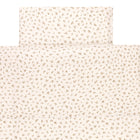 Das Bettwäscheset Musselin Zweige braun von KraftKids ist cremefarben, aus 100% Baumwolle handgefertigt und zeigt kleine verstreute braune Blütenmuster - liebevoll arrangiert und von oben betrachtet.