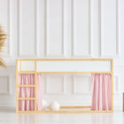 Ein minimalistisches Kinderbett mit Holzrahmen zeigt KraftKids Hochbettvorhänge Set 2+1 Musselin goldene Punkte auf Rosa für das Kura Bett in einem hellen weiß getäfelten Raum neben einer hohen geflochtenen Vase mit Pampasgras und zwei hölzernen Würfelhockern.