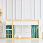 Minimalistisches Kinderzimmer mit einem IKEA Kura Hochbett, KraftKids Hochbettvorhänge Set 2+1 Musselin nilblau, zwei Holzhockern, einer gewebten Vase mit Pampasgras und einer weiß getäfelten Wand im Hintergrund.
